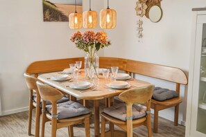 A dining table set with plates, glasses, and a vase of flowers. - Enjoy peace, space and comfort at Haringvliet 93 in Noordzeepark Ouddorp. This charming holiday home is located close to the beach and nature, making it ideal for families, friends and dog lovers. (Ouddorp)