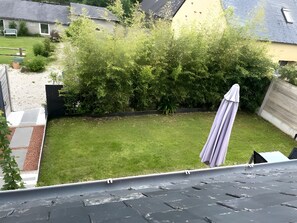 Ein Wohngrundstück mit Rasen, Holzzaun und einem Haus im Hintergrund.