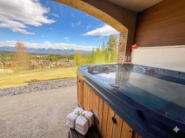 Ein Whirlpool mit Holzverkleidung, einem Handtuch und einer Glastür.