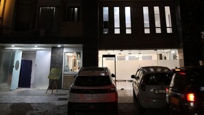 A building with a 'zen' sign, multiple windows, and parked cars in front. - Hotel Zen Inn (New Delhi)