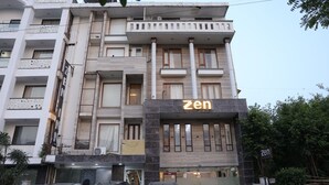 A multi-story building with a prominent 'zen' sign on the front. - Hotel Zen Inn (New Delhi)