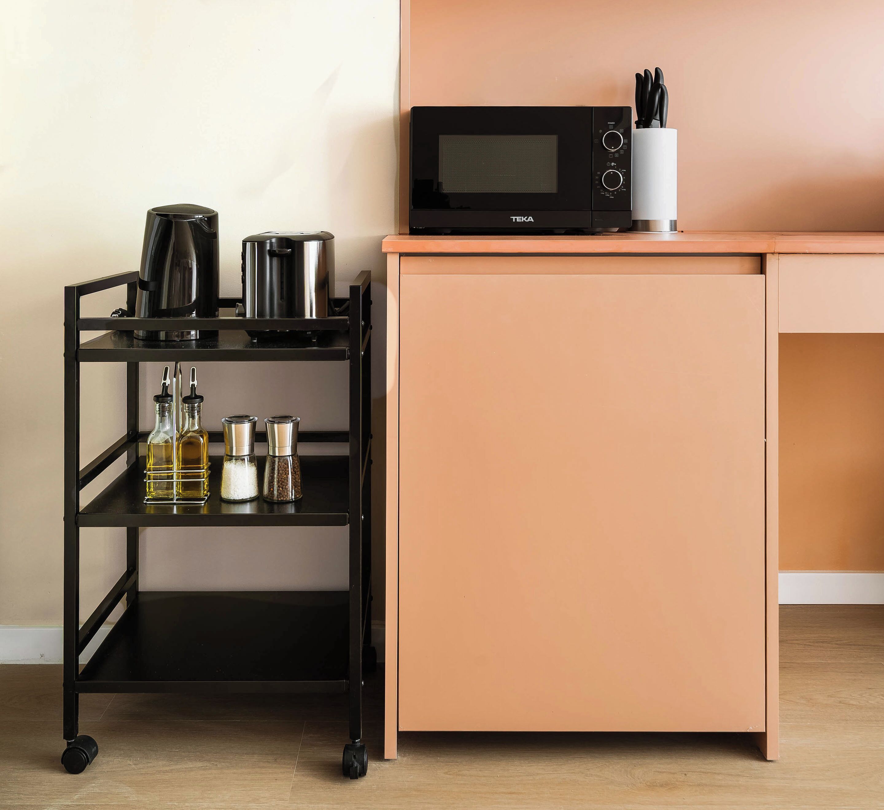 A kitchenette with a microwave, a coffee maker, and a spice rack.