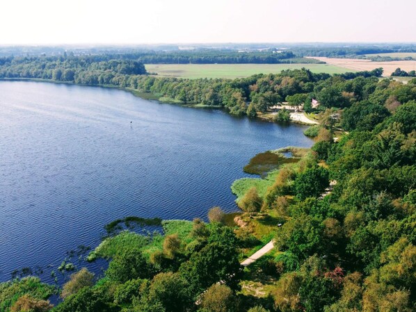 A river surrounded by dense greenery and a few buildings. - 5 Star Holiday Home in Ansager (Ansager)