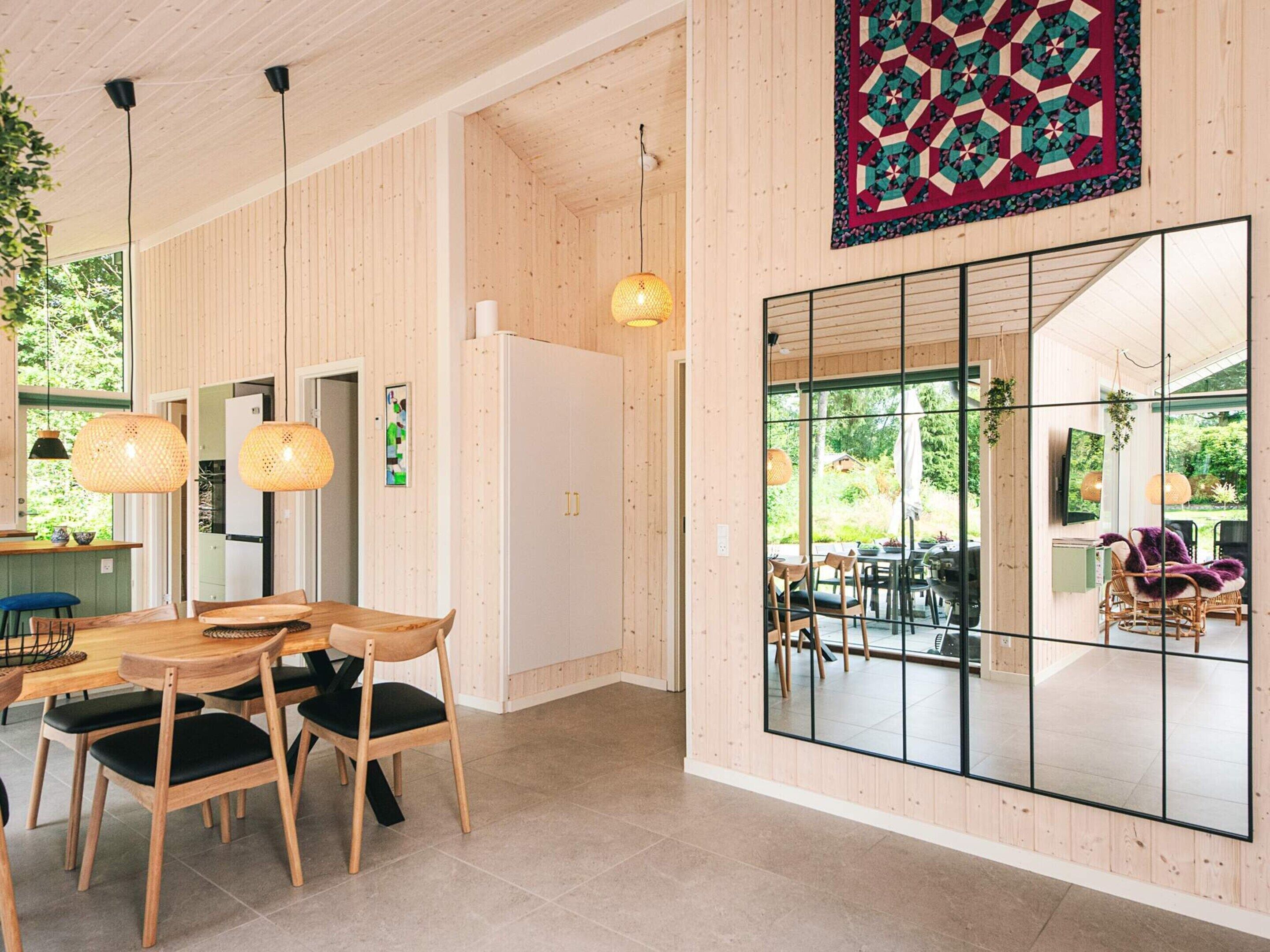Un interior moderno con comedor, cocina y ventanas amplias.