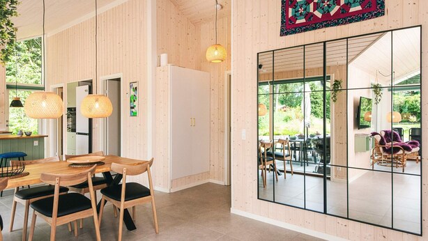 Un interior moderno con comedor, cocina y ventanas amplias.