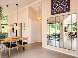 Un interior moderno con comedor, cocina y ventanas amplias.