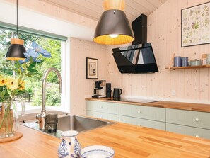 Una cocina moderna con armarios de madera, un lavamanos de acero inoxidable y una encimera de madera.