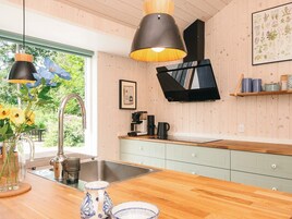 Una cocina moderna con armarios de madera, un lavamanos de acero inoxidable y una encimera de madera.
