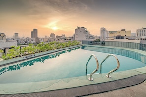 A rooftop swimming pool with a cityscape view at sunset. - Draco Residence Da Nang (Da Nang)