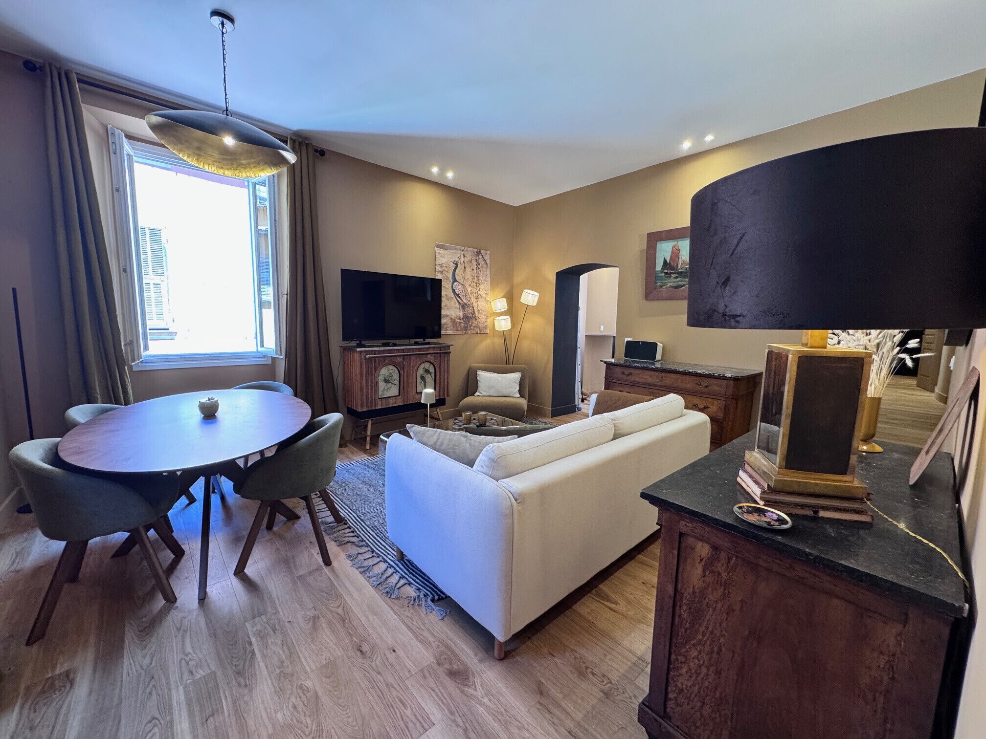 Una sala de estar moderna con comedor, televisor de pantalla plana, sofá, mesa de centro y chimenea.