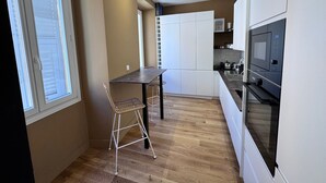 Une cuisine compacte avec un coin repas, un four à micro-ondes et une petite table.