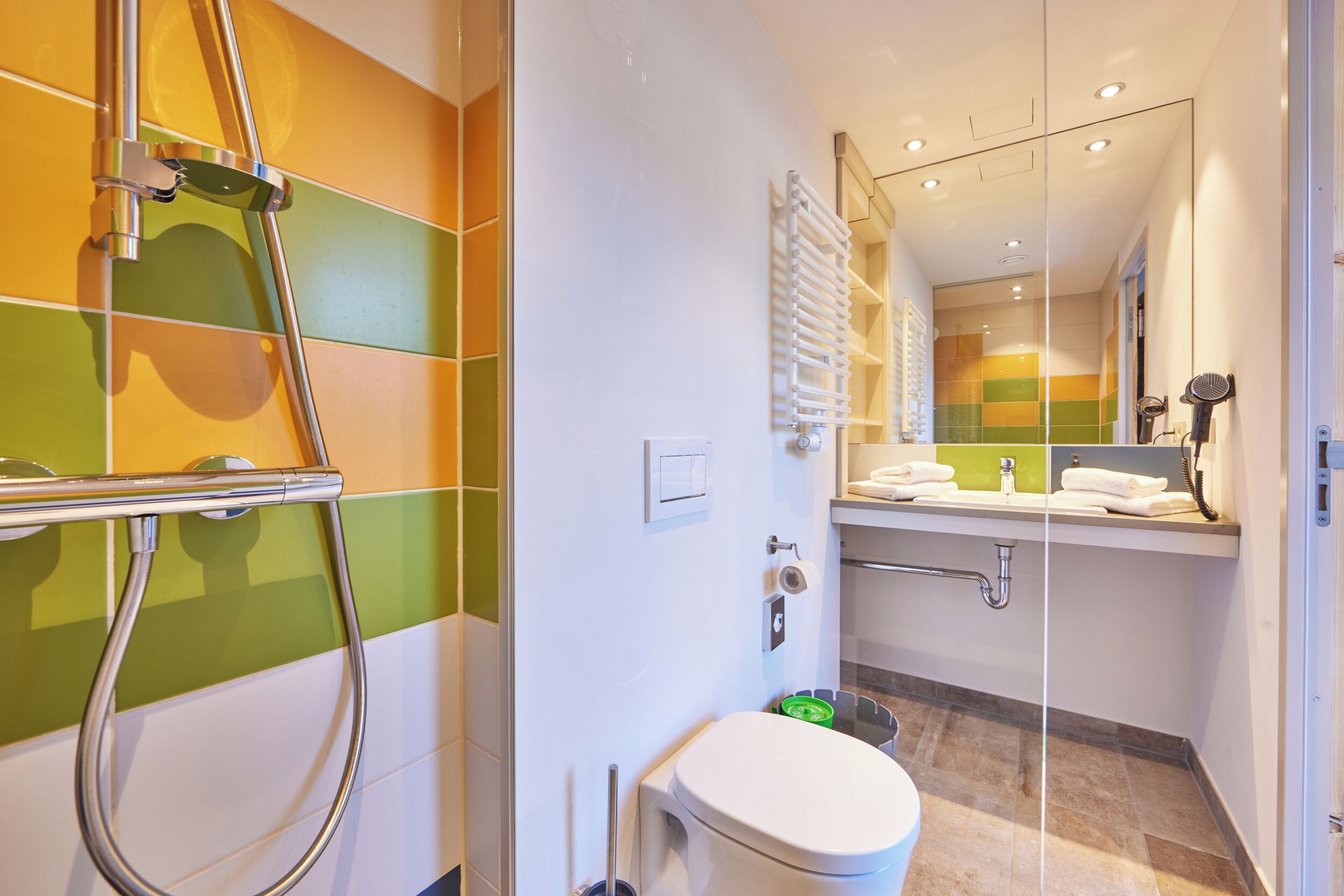 A modern bathroom with a shower, toilet, and sink.