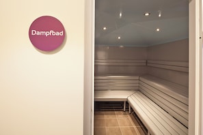 Una sala de sauna con bancos y un cartel que dice 'Dampfbad'.