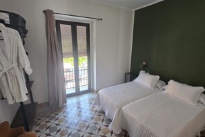 Ein Zimmer mit zwei Betten, einem Badezimmer und Blick ins Freie.