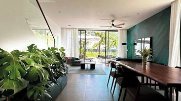 A modern interior with a dining area, large windows, and indoor plants.