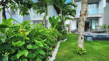 A well-maintained garden with a variety of plants and a clear pathway leading to a modern building with large windows.