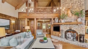 A rustic interior with a stone fireplace, wooden beams, and a cozy seating area. - Farm Hollow - luxury home with hot tub, covered fireplace (Banner Elk)