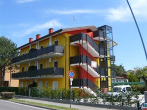 Ein mehrgeschossiges Gebäude mit Balkonen, einem Verbotsschild und einer Straßensicht.