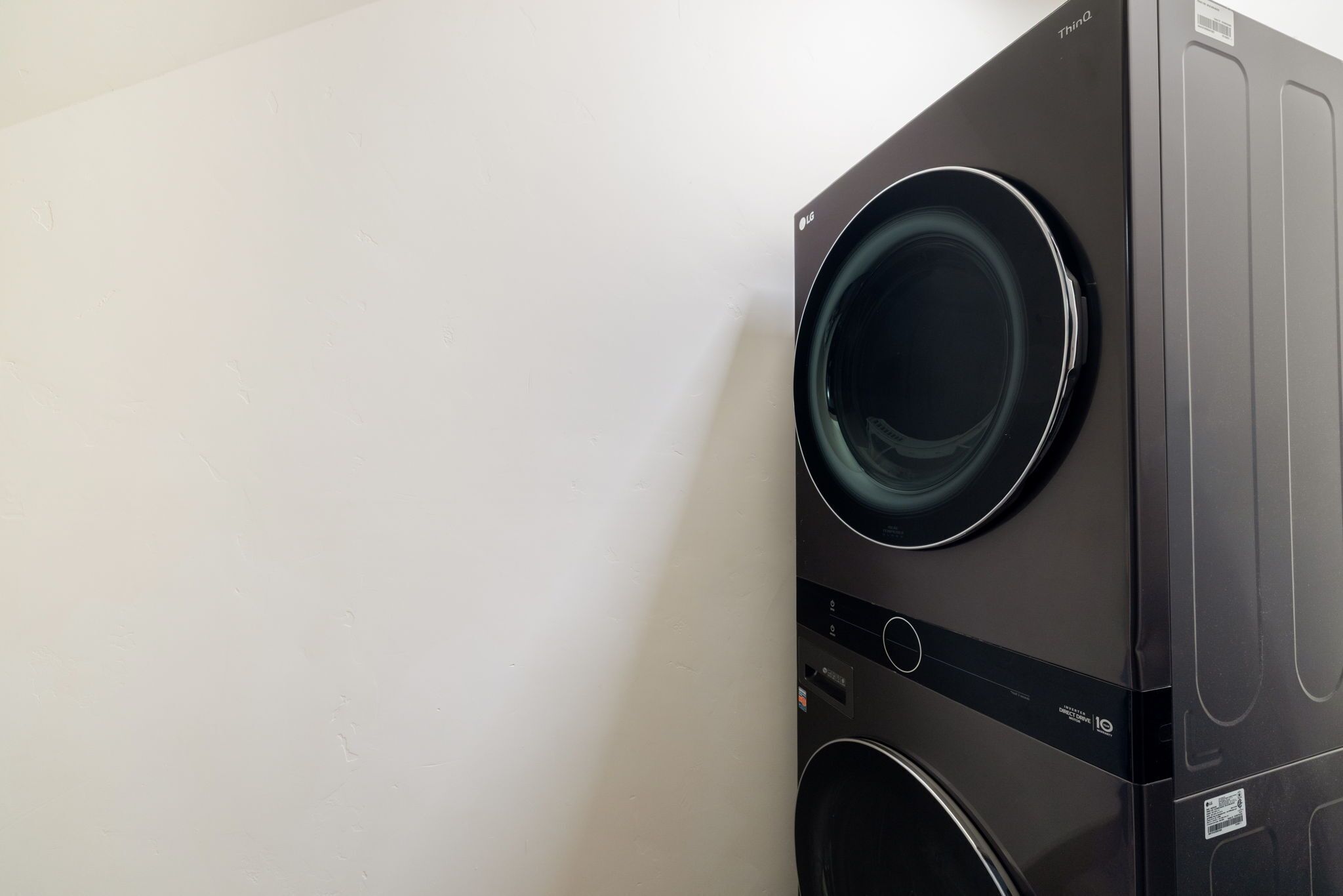 A black washing machine with a control panel and a label indicating it is a LG model.