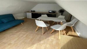 A compact living space with a dining area, a sofa, and a kitchenette. - 200 m plage - Rue piétonne à 300 m - jardin (Berck)