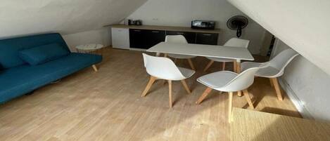 Un espacio habitable compacto con comedor, sofá y kitchenette.
