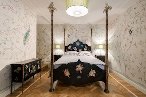 A four-poster bed with floral bedspread, a nightstand with a lamp, and a dresser with floral designs. - Venice Prestige - Celestina on the Grand Canal R&R (Venice)