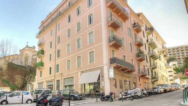 A multi-story building with balconies, parked cars, and motorcycles on the street. - CLOCARLUCCI - AJACCIO (AJACCIO)