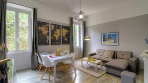 A modern living room with a dining table, sofa, and artwork on the walls. - CLOCARLUCCI - AJACCIO (AJACCIO)