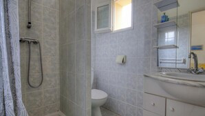 A bathroom with a shower, toilet, sink, and a window. - Casetta des Oliviers (SARTENE)