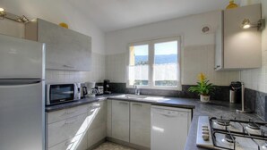 A modern kitchen with a refrigerator, microwave, coffee maker, and dishwasher. - Casetta des Oliviers (SARTENE)
