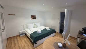 Una camera da letto con un letto, comodini, una scrivania e una sedia.