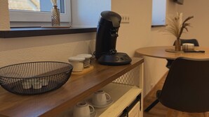 Una cocina con cafetera, un tazón y una ventana con vistas.