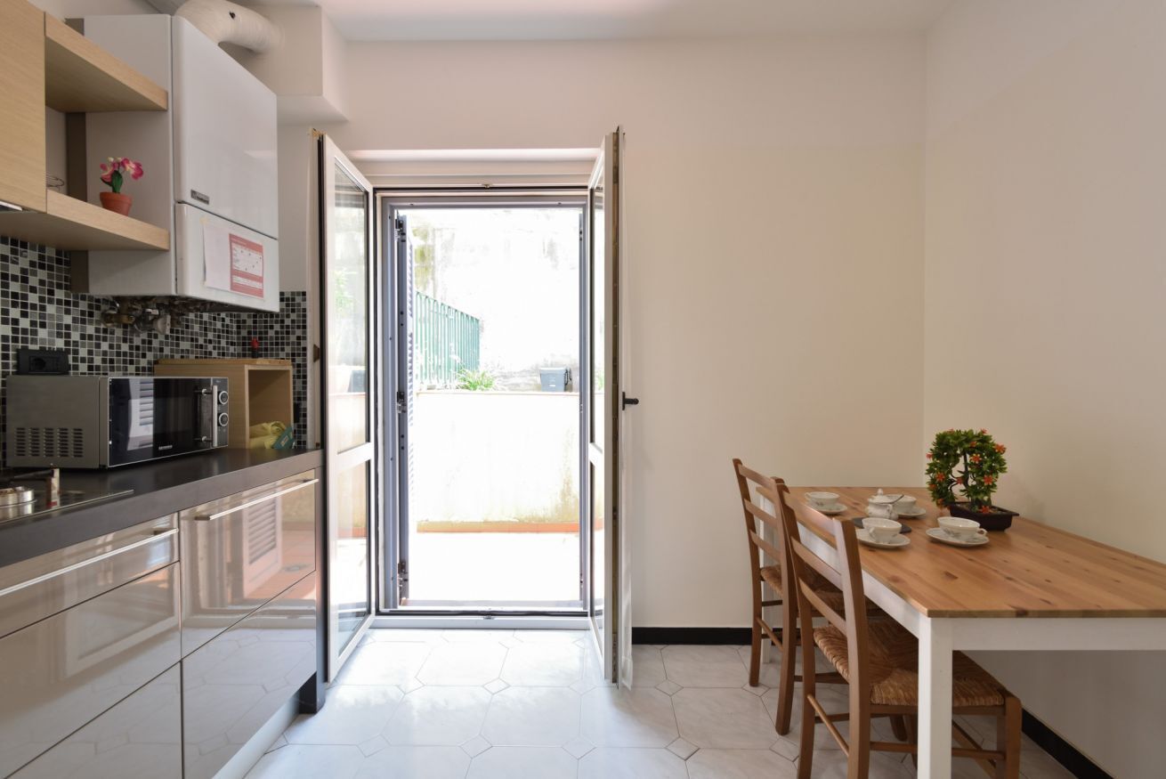 Una cocina compacta equipada con microondas, armarios y una zona de comedor con mesa y sillas.