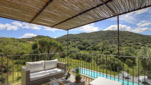 A balcony with a view of a mountainous landscape, a pool, and outdoor seating. - Casa Andressi - Figari (Figari)
