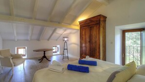A bedroom with a bed, a chair, a table, a lamp, and a wardrobe. - Casa Andressi - Figari (Figari)