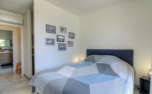 A bedroom with a bed, a nightstand, a wall-mounted lamp, and framed pictures. - Villa Corsu - PORTO VECCHIO (PORTO VECCHIO)