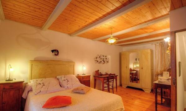 A bedroom with a wooden ceiling, a bed with pillows, a nightstand, a desk, and a wardrobe. - Fanny - POGGIO MARINACCIO (POGGIO MARINACCIO)