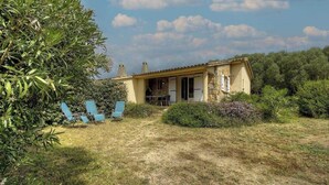 A house with a stone facade, a covered porch, and a garden with chairs. - Ogliastrello sheepfolds (FIGARI)
