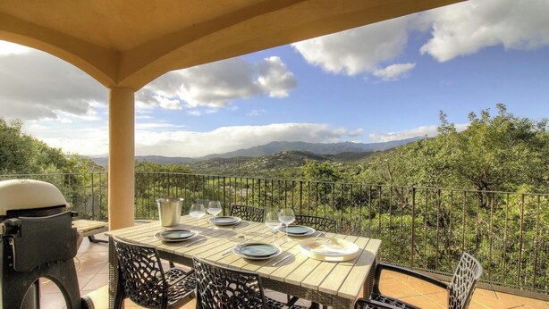 A table set outdoors with a view of mountains and greenery. - Villa chjara - SAINTE LUCIE DE PORTO VECCHIO (SAINTE LUCIE DE PORTO VECCHIO)