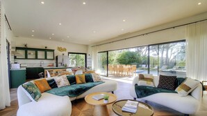 Ein großzügiges Wohnzimmer mit einer Sofagarnitur, einem Couchtisch und Blick auf die Außenpatio-Terrasse.