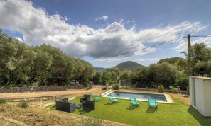 Ein Garten mit Schwimmbad, Rasen und Gartenmöbeln.