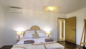 A bedroom with a bed, bedside lamps, a ceiling light fixture, a wooden door, and a mirror. - Casa Allegrini - VICO (VICO)