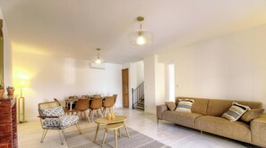 A living room with a sofa, chairs, a dining table, and a staircase. - Casa Allegrini - VICO (VICO)