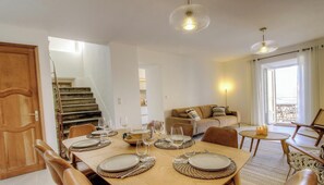 A dining area with a table set for four, a sofa, and a staircase. - Casa Allegrini - VICO (VICO)