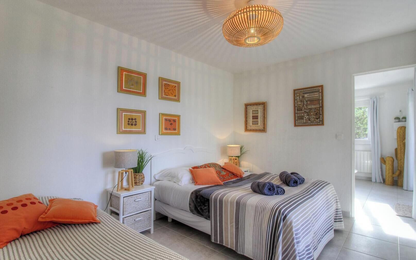 Une chambre à coucher avec un lit, des tables de chevet et des œuvres d’art murales.
