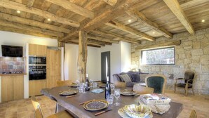 A rustic dining area with a wooden table set for a meal, stone walls, and a stone fireplace. - Casa Scaledda - BOCOGNANO (BOCOGNANO)