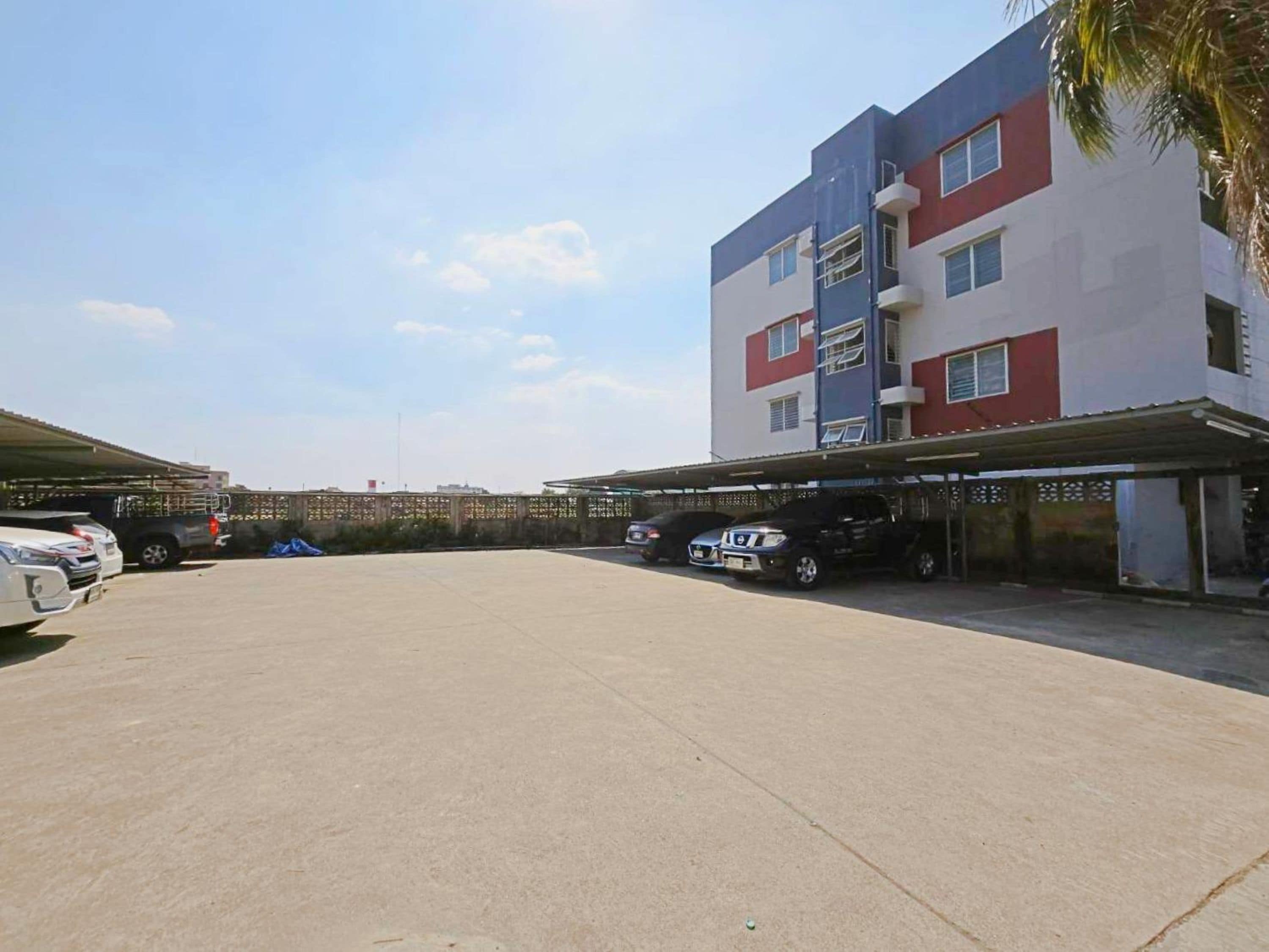 A multi-story building with a parking area in front.