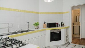 A kitchen with a gas stove, sink, microwave, and oven. - Beautiful 1BR in the heart of Condesa featuring a spacious equipped kitchen, cozy TV lounge, full bathroom, washer, and comfortable bedroom. Sofa bed available for 1 child. Perfect for enjoying one of CDMX’s best neighborhoods. (Cuauhtémoc)
