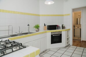 A kitchen with a gas stove, sink, microwave, and oven. - Beautiful 1BR in the heart of Condesa featuring a spacious equipped kitchen, cozy TV lounge, full bathroom, washer, and comfortable bedroom. Sofa bed available for 1 child. Perfect for enjoying one of CDMX’s best neighborhoods. (Cuauhtémoc)