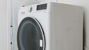 A front-loading washing machine in a room with white walls and a tiled floor. - Beautiful 1BR in the heart of Condesa featuring a spacious equipped kitchen, cozy TV lounge, full bathroom, washer, and comfortable bedroom. Sofa bed available for 1 child. Perfect for enjoying one of CDMX’s best neighborhoods. (Cuauhtémoc)